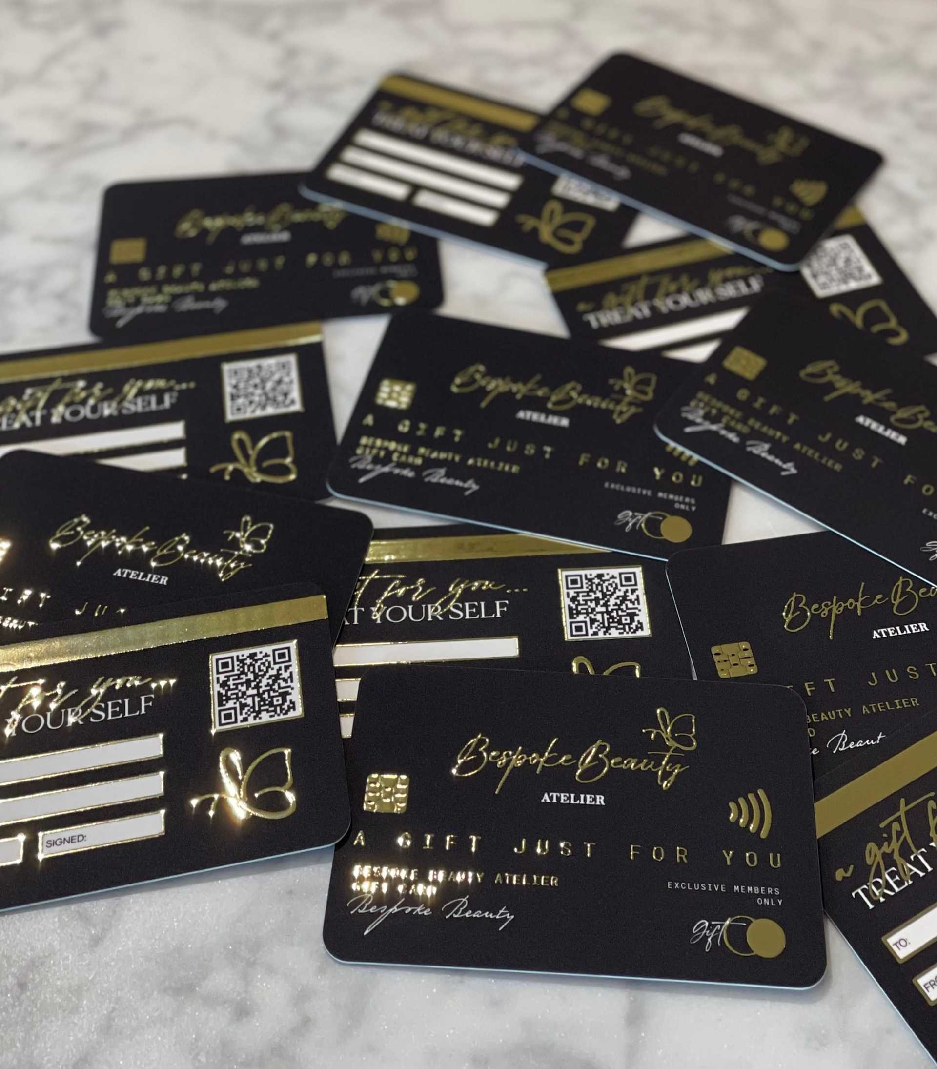 Black and gold gift cards scattered on a marble surface with "Bespoke Beauty" branding.