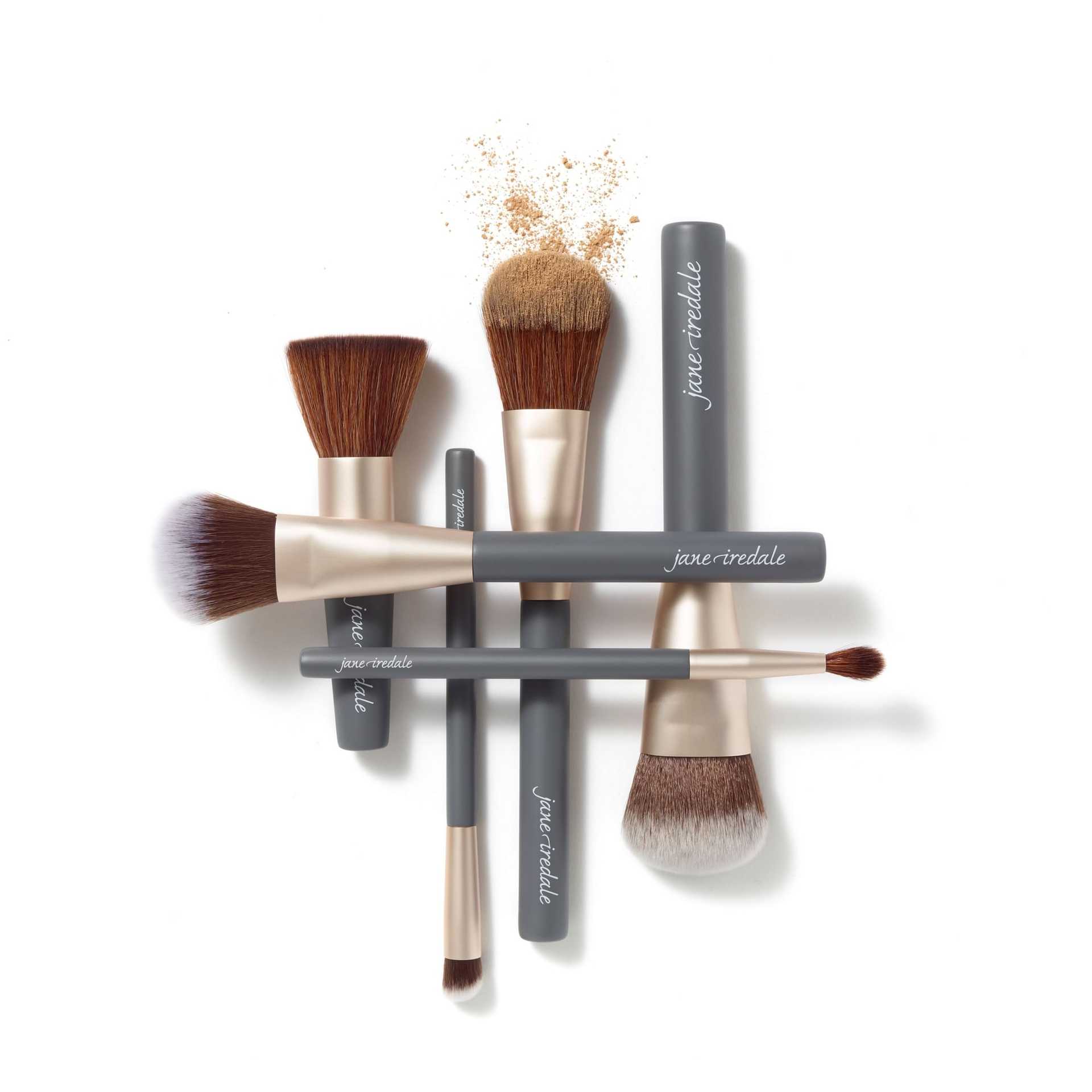 Makeup brushes and tools arranged creatively on a white background.