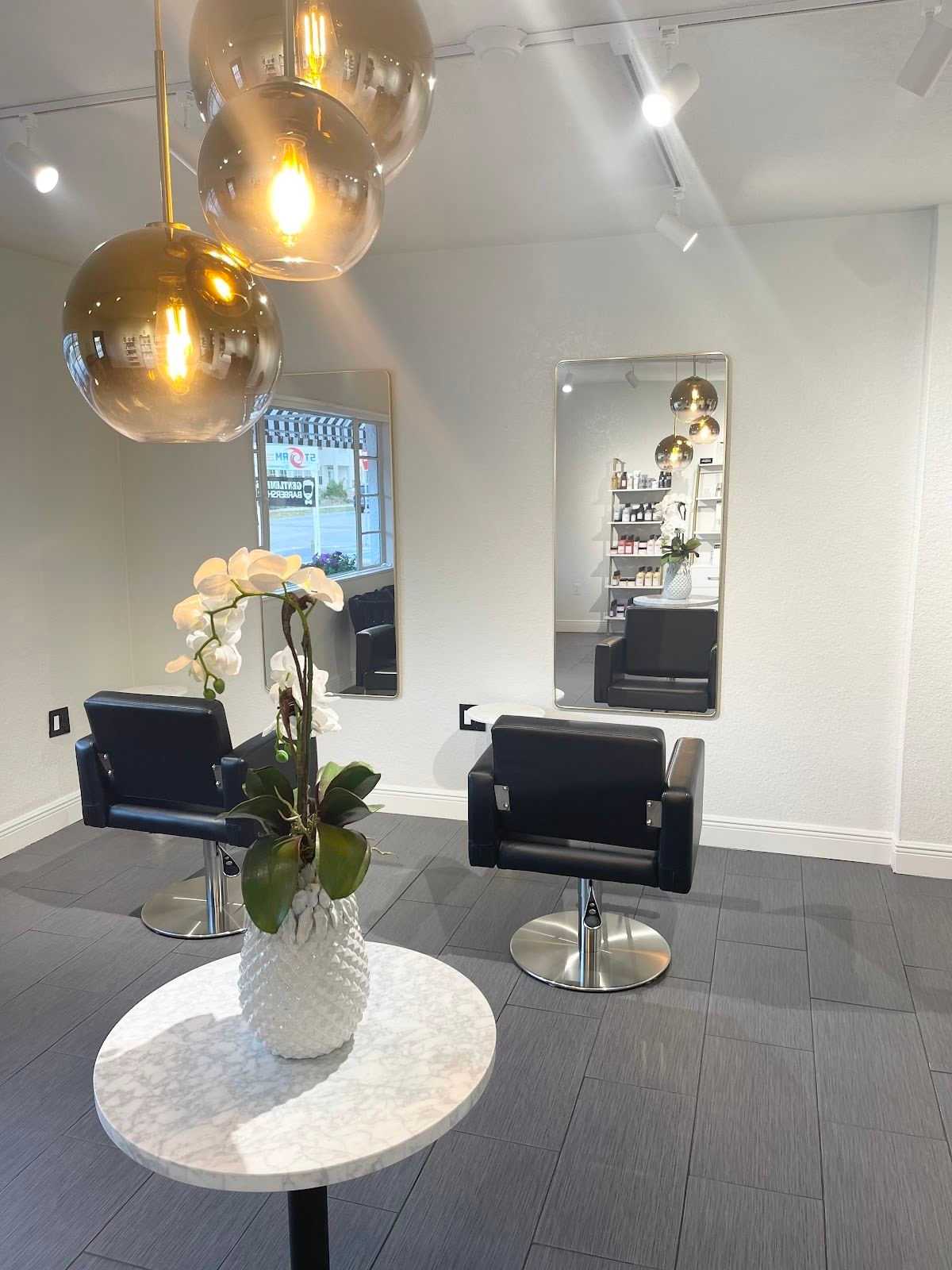 Modern hair salon interior with stylish chairs and mirrors.